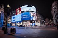 Night view of illuminated billboards at Piccadilly Circus, showcasing vibrant city life in London.